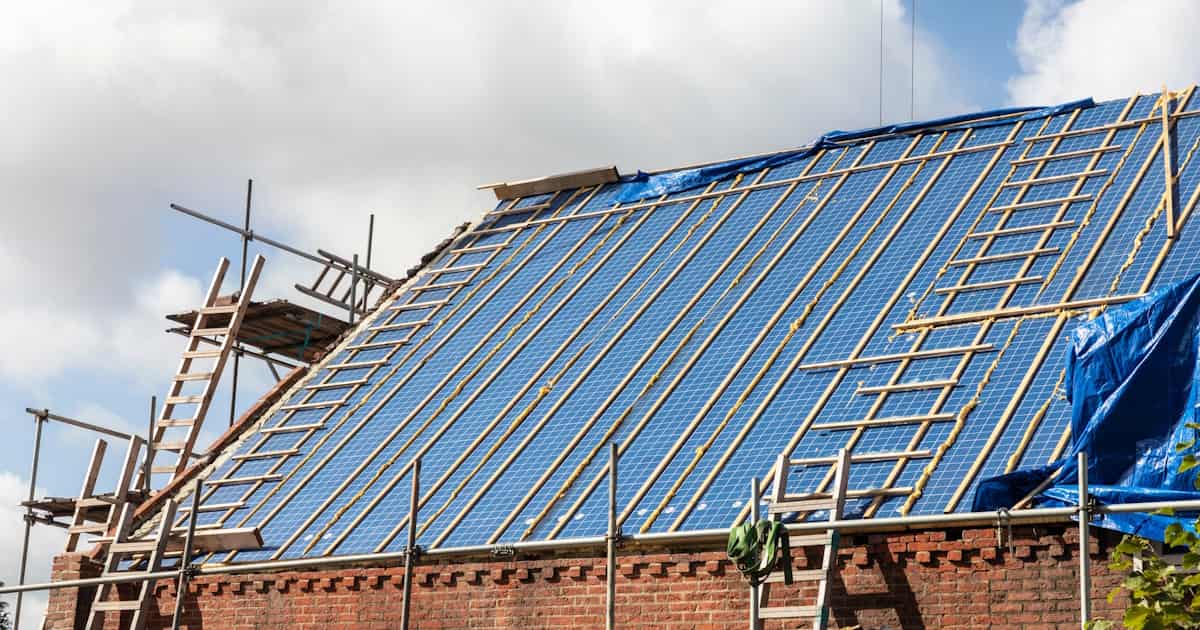 De renovatie van een schuin dak is in volle gang. Een gedeelte van de tengellatten en panlatten is op het dakoppervlak bevestigd.