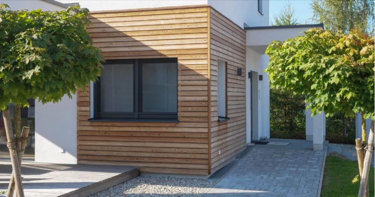 Een huis heeft een houten gevelbekleding met verticaal geplaatste latten.