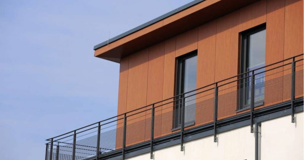 Een groot huis heeft op de bovenverdieping een houten gevelbekleding