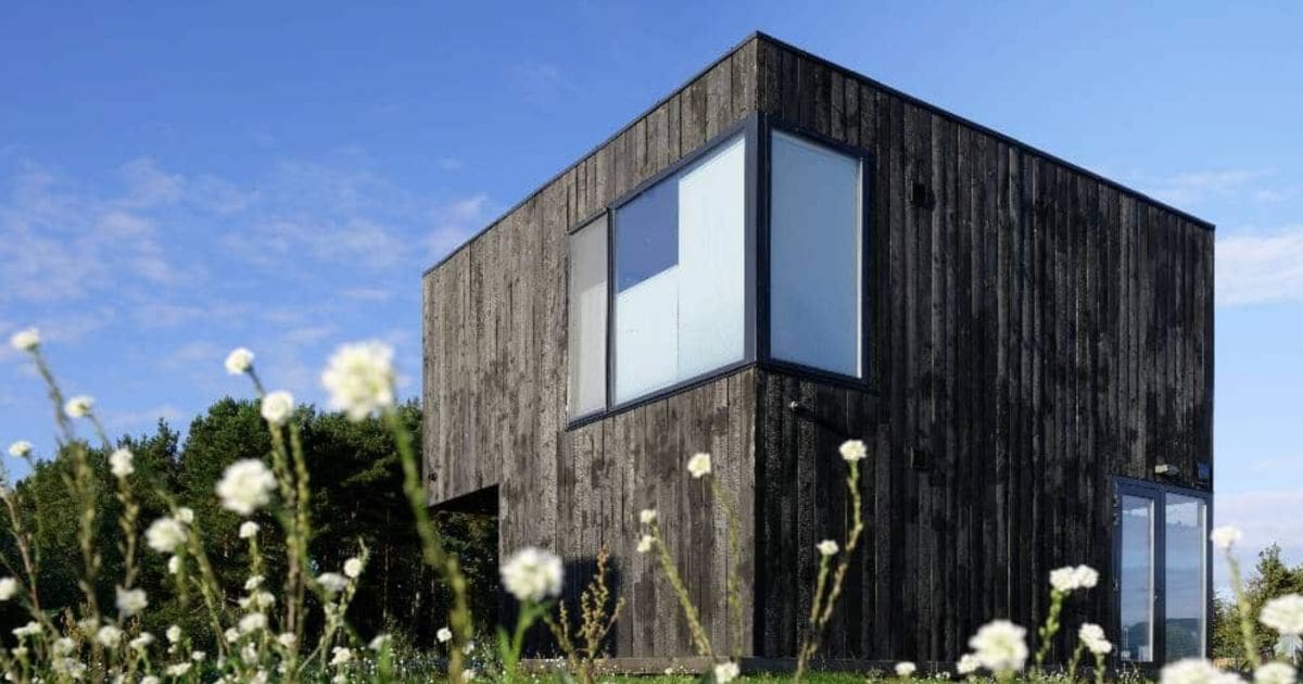 Een huis heeft een houten gevelbekleding met verticaal geplaatste latten.