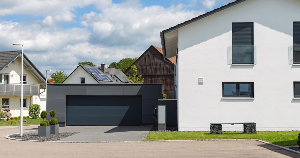 Een woning met een gevel waarop keim is aangebracht. De keim is helder wit. Op de foto is ook een garage te zien.