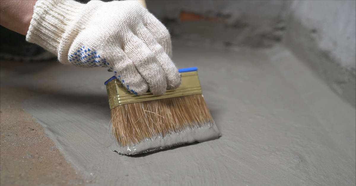 Cementmortel wordt aangebracht op de keldervloer om deze waterdicht te maken