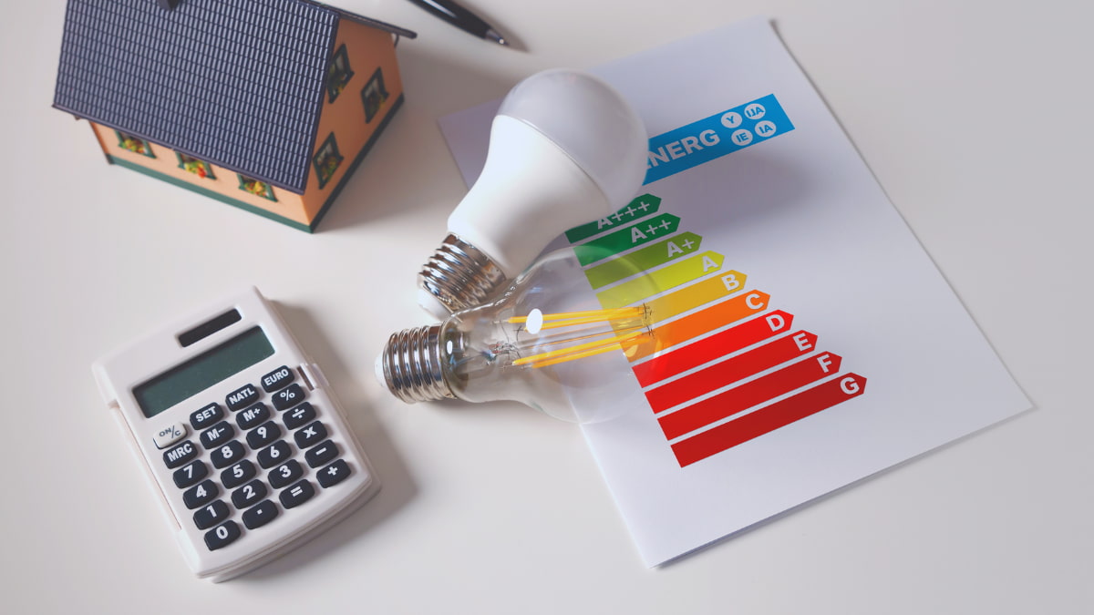 Energielabel van A+++ tot G met rekenmachine, miniatuurwoning en ledlampen als symbool voor de kosten van een energielabel