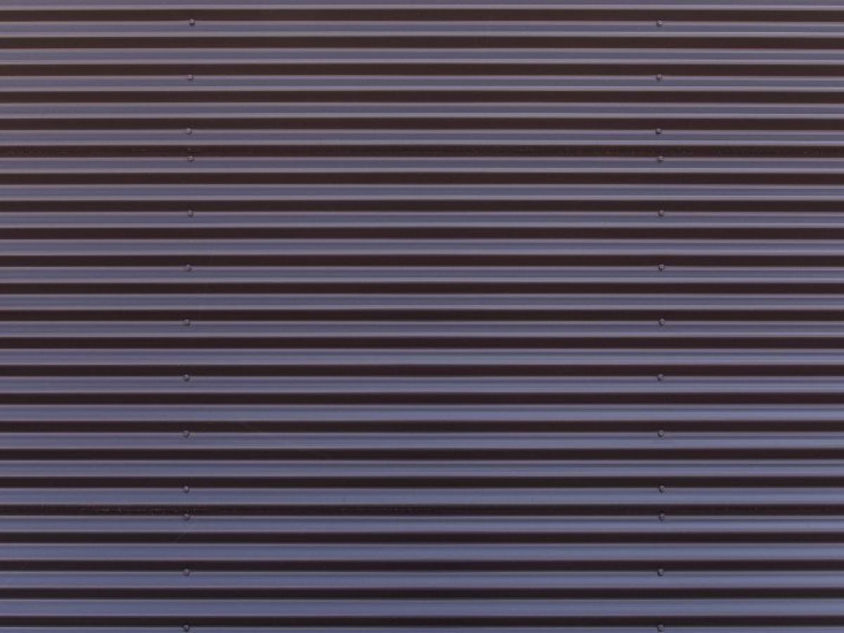 Close-up van kunststof gevelbekleding met horizontale profielplaten in een donkere kleur.
