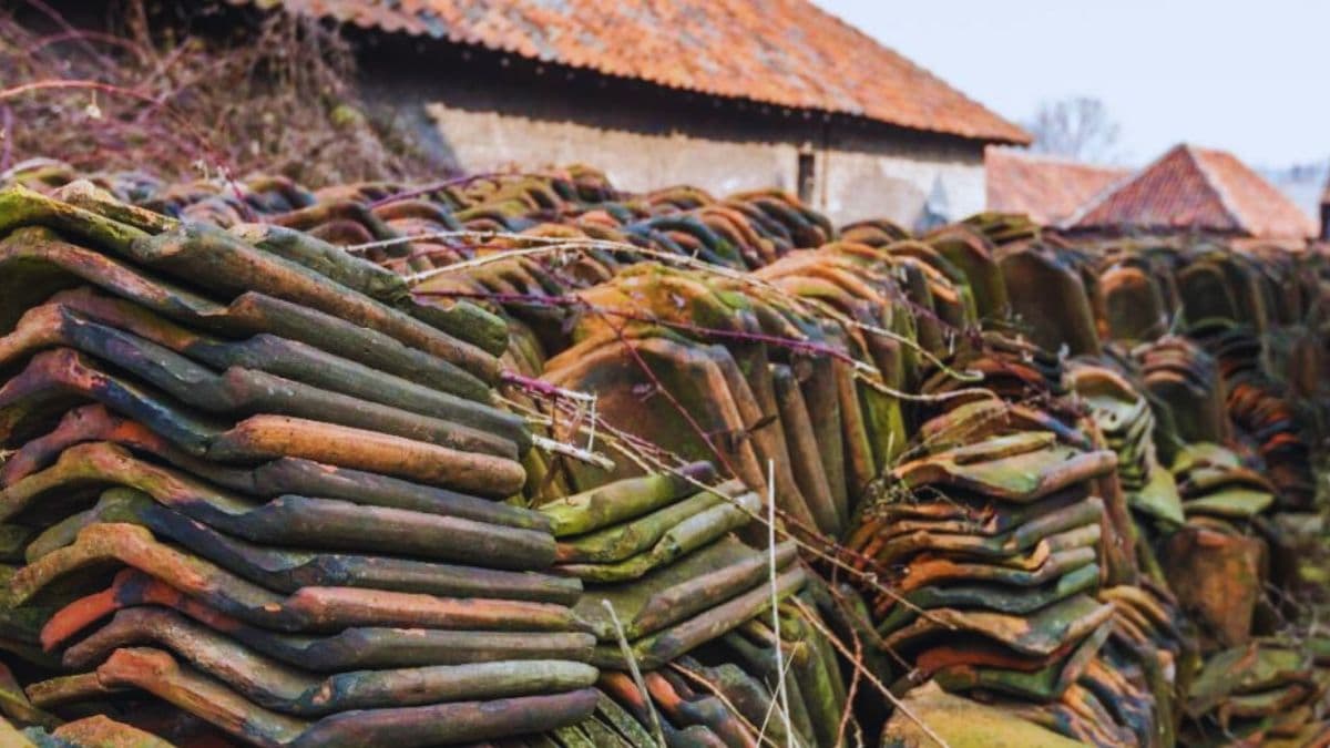 Een stapel oude Boomse pannen met mos.