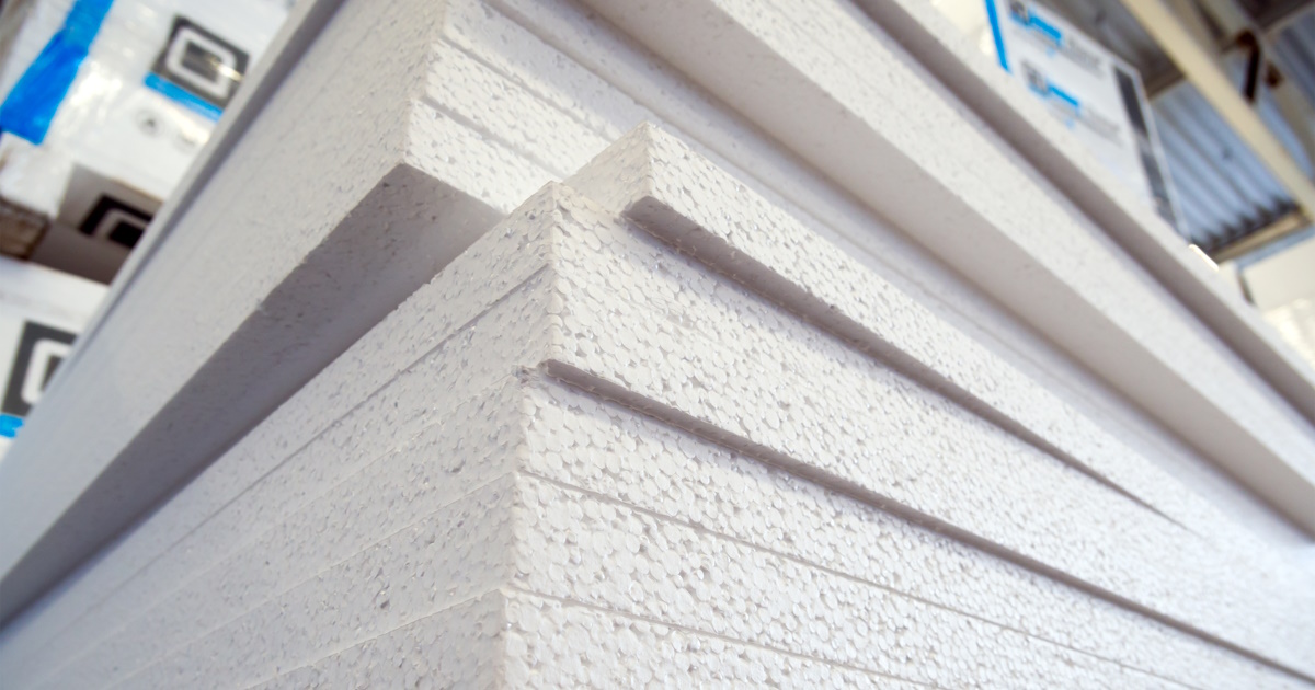 Een hoge stapel witte isolatieplaten, gemaakt van geëxpandeerd polystyreen