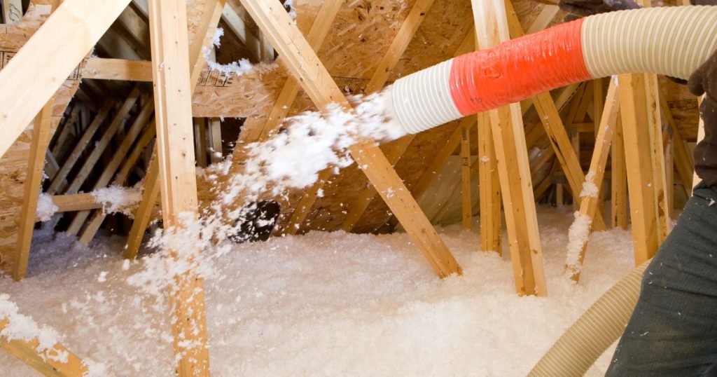 Een dakisolatiespecialist spuit schuimisolatie op de zoldervloer van een dak: zoldervloerisolatie is een goed alternatief op gewone dakisolatie, zolang je kiest voor een materiaal met een voldoende hoge Rd-waarde.