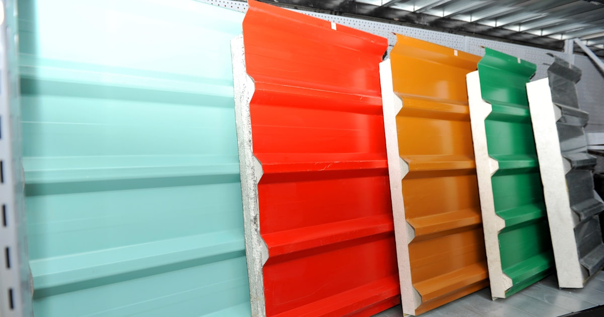 Een aantal sandwichpanelen in verschillende diktes en kleuren op een rij