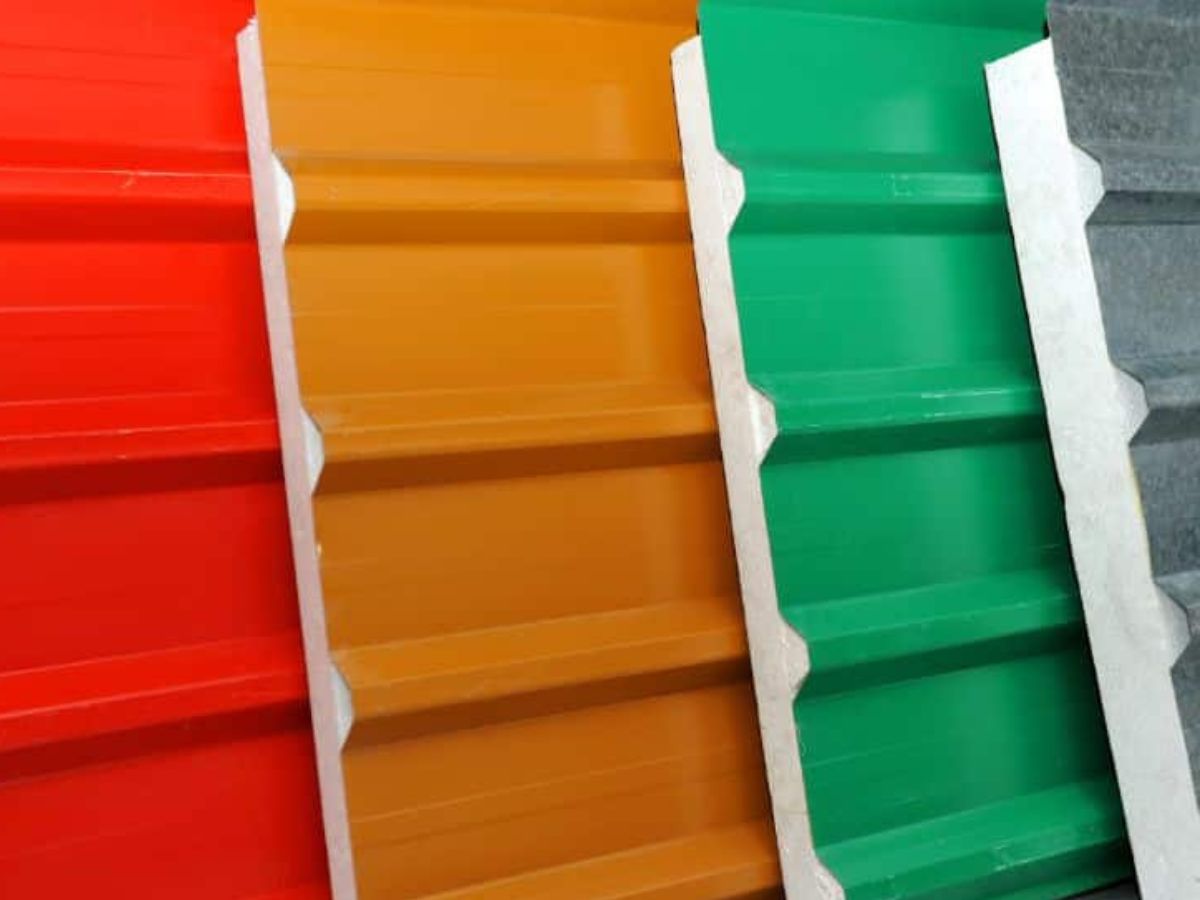 Close-up van verschillende kleuren sandwichpanelen, waaronder rood, oranje, groen en grijs, met een duidelijk zichtbare structuur en randafwerking.