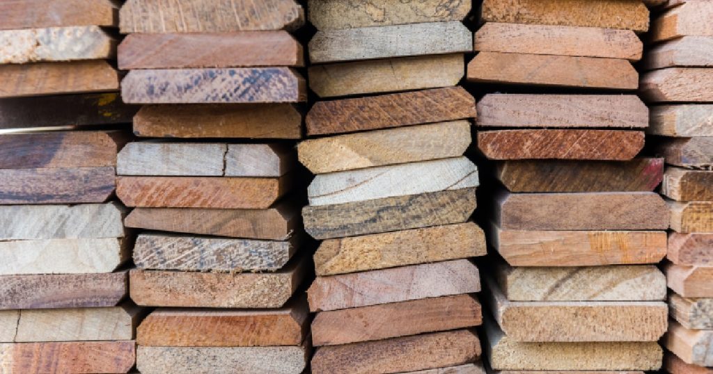 Een stapel met steigerhouten planken die gebruikt zullen worden voor een nieuwe trap. De planken hebben verschillende kleuren dankzij het onvoorspelbare karakter van steigerhout.