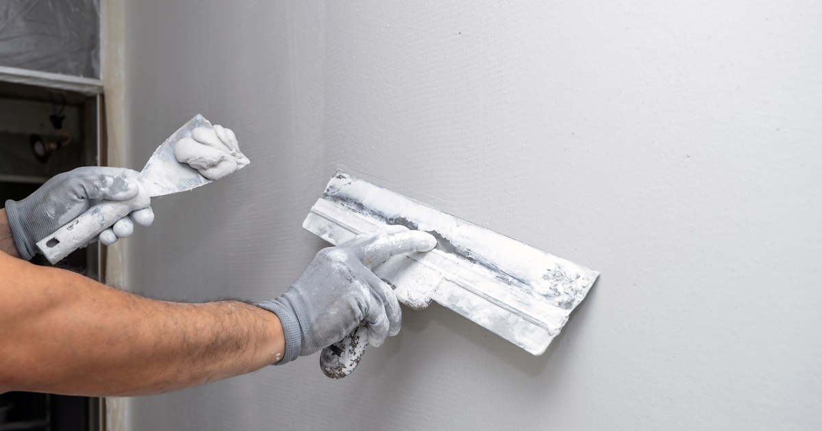 Een stucadoor gebruikt een spackmes om een egaal oppervlak te creëren. 