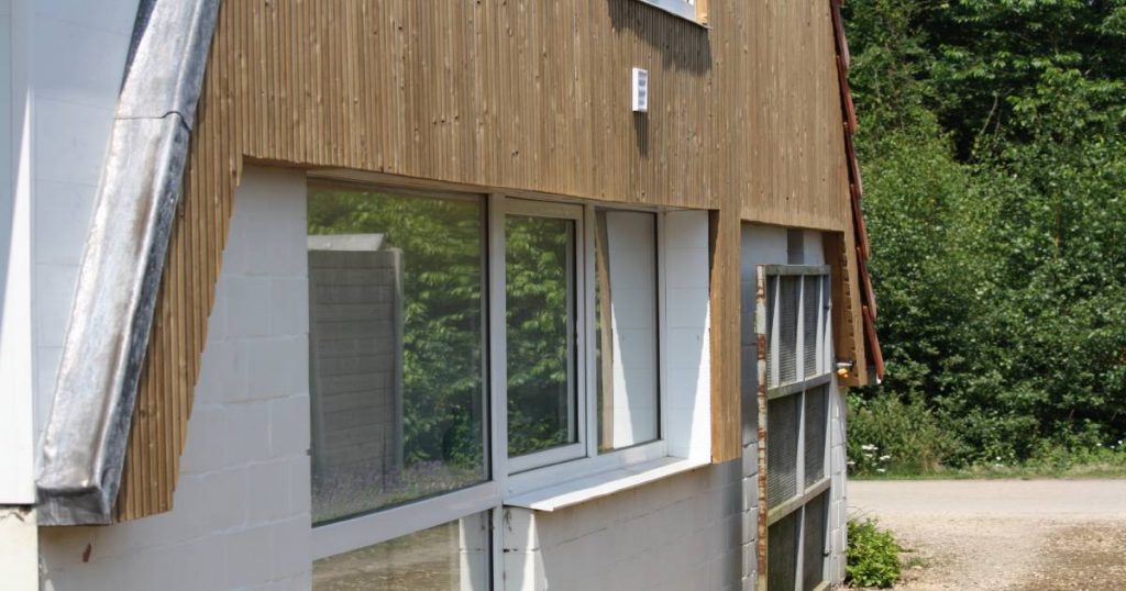 Een gevel waarop gevelbekleding van thermowood wordt aangebracht. De gevel is nog niet af.