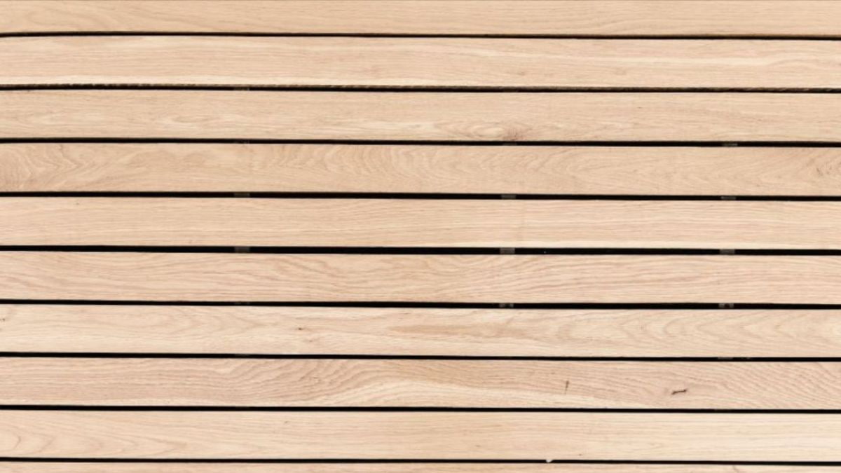 Close-up van een houten gevelpaneel in parallellogramvorm, van thermowood, met een lichtbruine kleur en duidelijk zichtbare houtnerf.