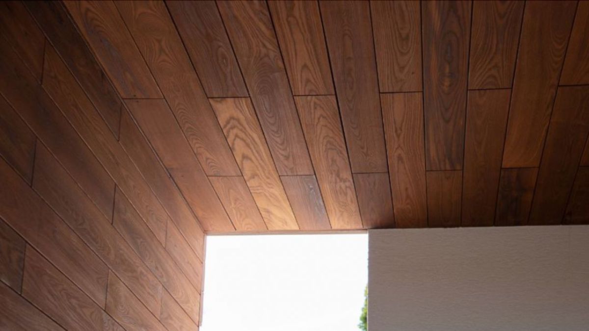 Close-up van houten thermowood gevelpanelen (schroten) als plafondbekleding.