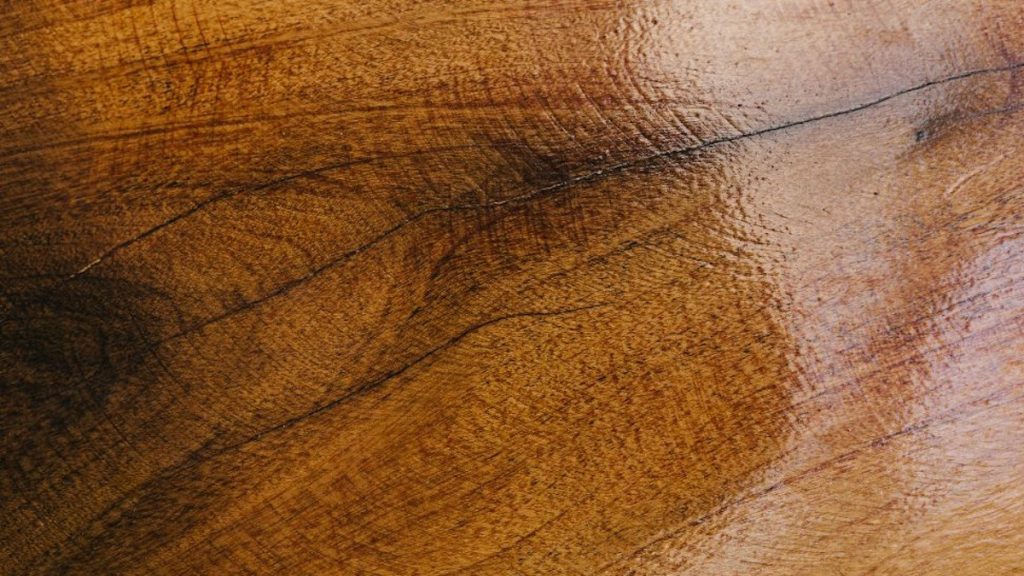 Een oppervlak gemaakt van hout met een laag olie. Het hout heeft een warmte tint.
