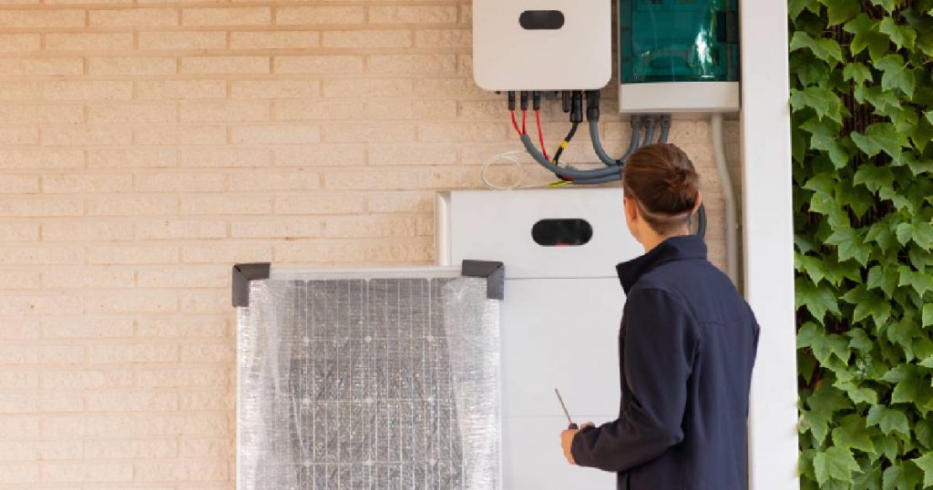 Een professioneel installateur sluit een thuisbatterij aan op een installatie met zonnepanelen.