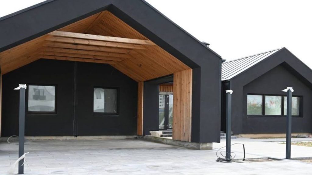 De zwarte sierpleister is bij deze woning gecombineerd met hout. 