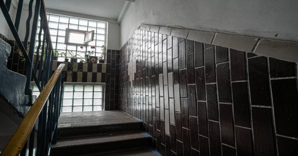Trap waarlangs lambrisering loopt. Hier koos men voor zwarte en witte verticaal georiënteerde tegels.